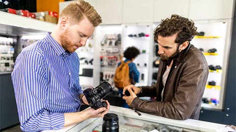 Vendeur et client discutant dans un magasin d'électronique